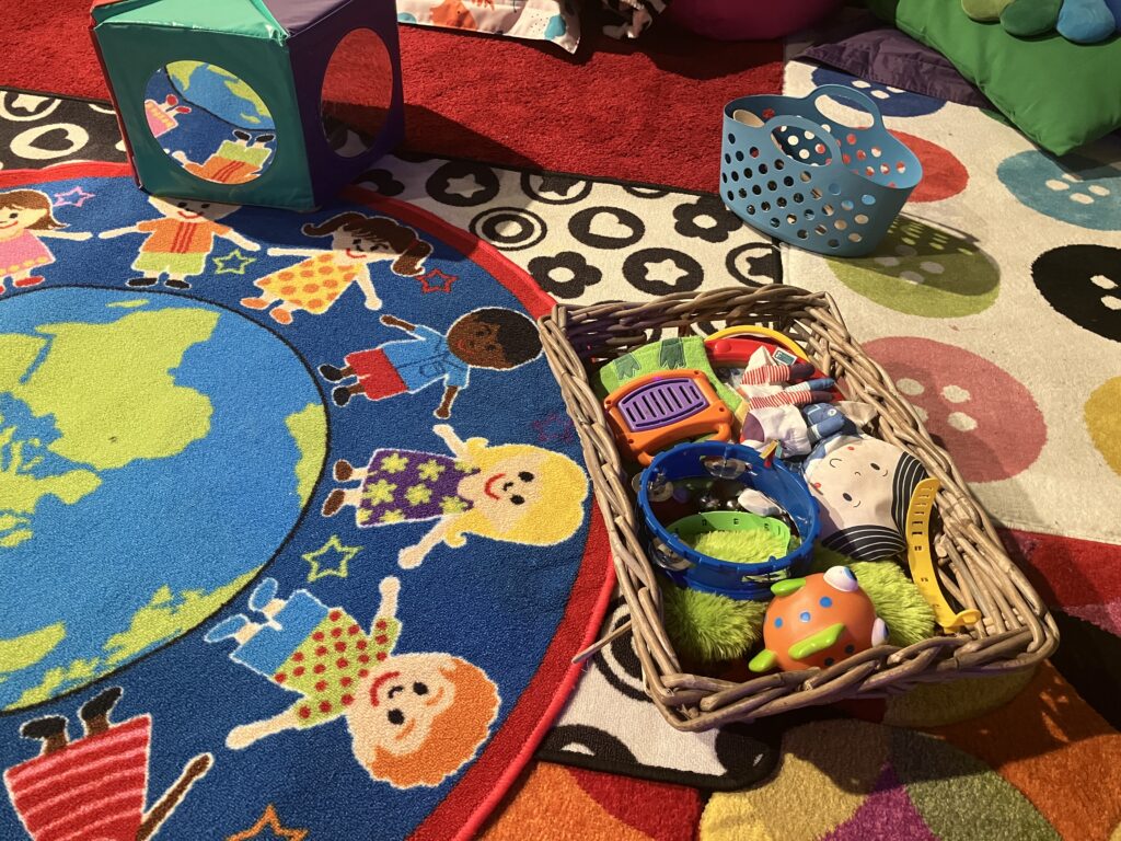Set up for Baby & Me, colourful rugs and toys in baskets